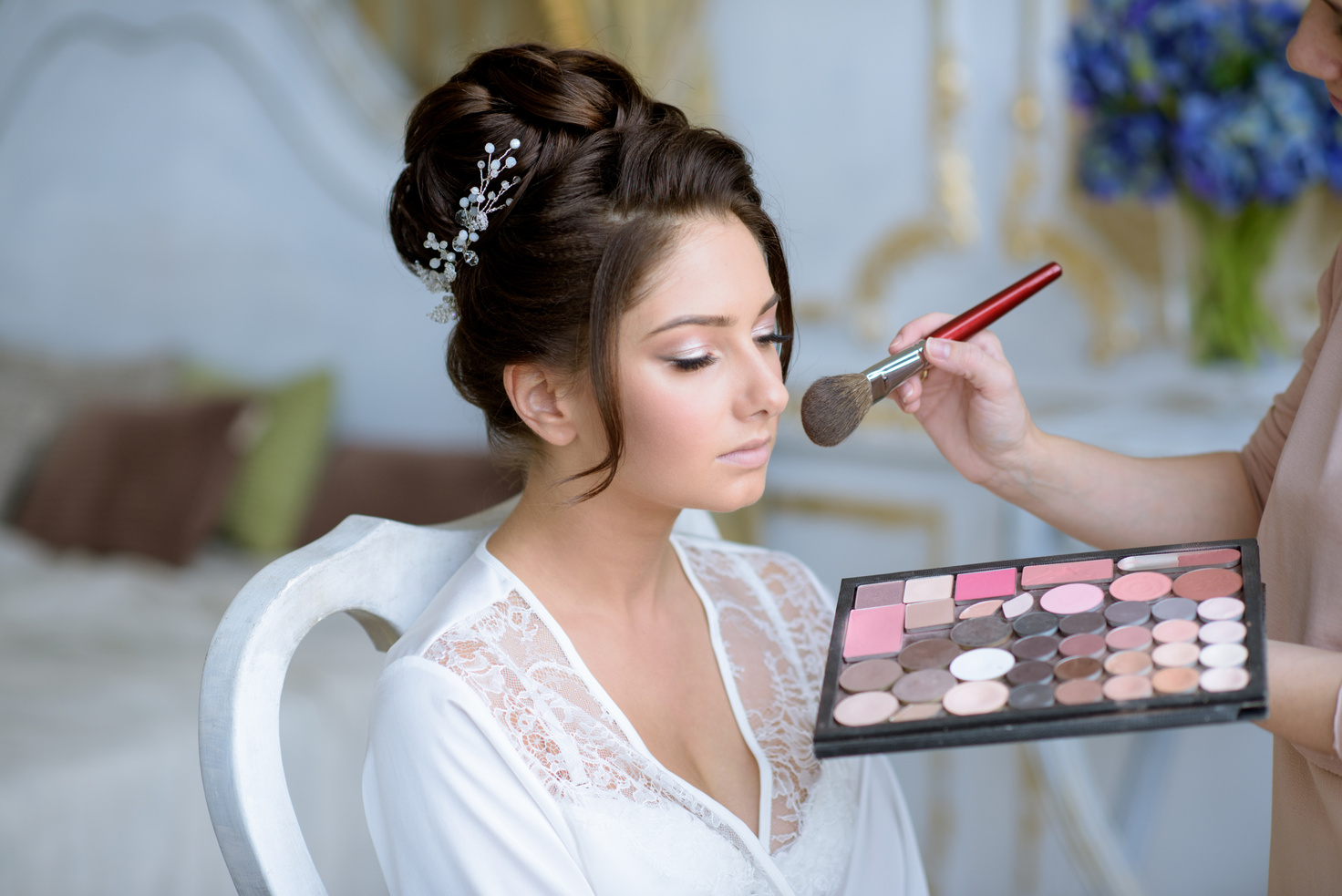 Wedding makeup artist making a make up for bride